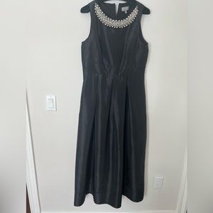 Sleeveless black dress with beaded detail at neckline